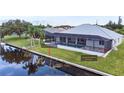 Home boasts a travertine pool deck and concrete seawall at 15267 Appleton Blvd, Port Charlotte, FL 33981