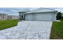 Two-car garage, paver driveway, and a modern exterior elevation at 15267 Appleton Blvd, Port Charlotte, FL 33981