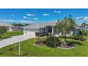 Single story home, paved driveway, and lush landscaping at 15418 Alcove Cir, Port Charlotte, FL 33981
