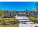 Modern home with three-car garage and paver driveway at 7161 Manasota Key Rd, Englewood, FL 34223