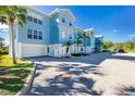 Light blue, two-story building with attached garages and palm trees at 3923 Cape Haze Dr # 306, Rotonda West, FL 33947