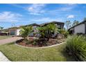 Landscaped yard with tropical plants surrounds a one-story house with gray siding at 1337 Sorrell Way, North Port, FL 34289