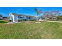Single story home with palm tree and green lawn at 105 Crestview Dr, Englewood, FL 34223