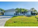 Ranch-style house with a large driveway and green lawn at 78 Lima St, Punta Gorda, FL 33983