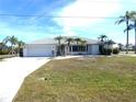 White single-story home with palm trees and a large grassy yard at 78 Lima St, Punta Gorda, FL 33983