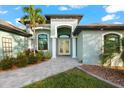Inviting home exterior featuring a light green facade and a paved walkway at 15576 Aldama Cir, Port Charlotte, FL 33981