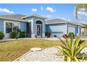 Light blue house with a landscaped yard and entrance at 13838 Begonia Cir, Port Charlotte, FL 33981