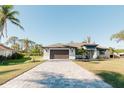 Modern home exterior with paved driveway and lush lawn at 2213 Oleada Ct, Englewood, FL 34224