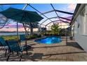 Relaxing pool area with covered patio and lake view at 11564 Renaissance Blvd, Venice, FL 34293