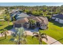 Aerial view of single-Gathering home with two-car garage, lush landscaping, and circular driveway at 2 Marker Rd, Rotonda West, FL 33947