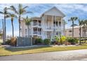 Two-story building exterior, featuring light-colored siding and landscaping at 11000 Placida Rd # 1603, Placida, FL 33946