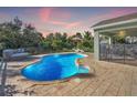 Freeform swimming pool with a paved patio and lounge chairs at 2251 Meetze St, Port Charlotte, FL 33953