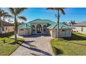 House exterior showcasing a green metal roof and a paver driveway at 9567 Honeymoon Dr, Port Charlotte, FL 33981