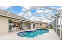 Relaxing kidney-shaped pool with a screened enclosure and patio furniture at 171 Medalist Rd, Rotonda West, FL 33947