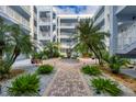 Lush courtyard with fountain, brick walkways, and tropical plants at 2001 Bal Harbor Blvd # 2203, Punta Gorda, FL 33950
