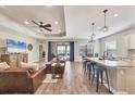 Open concept living room and kitchen with hardwood floors and brown leather sofa at 26812 Pavin Dr, Englewood, FL 34223