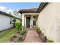 Brick walkway leading to home's entrance with small patio and landscaping at 2759 Lavandula Ct, North Port, FL 34289