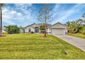 House exterior featuring a spacious lawn and driveway at 7297 Jennifer Dr, Port Charlotte, FL 33981
