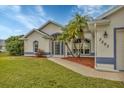 Front view of a single-story house with a landscaped yard and palm trees at 7297 Jennifer Dr, Port Charlotte, FL 33981