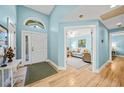 Bright and airy entryway with light blue walls and wood-look flooring at 8527 Creekview Ln, Englewood, FL 34224