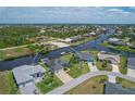 Bird's-eye view of a canal-front home with lush landscaping at 9222 Melody Cir, Port Charlotte, FL 33981
