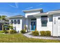 Front entrance with teal door, shutters, and walkway at 15448 Melport Cir, Port Charlotte, FL 33981