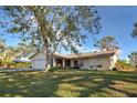 Single-story house with a large yard and mature trees at 1951 Greenlawn Dr, Englewood, FL 34223