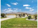 Single-story house with yellow exterior, landscaping and a two-car garage at 233 Marker Rd, Rotonda West, FL 33947