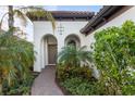 Attractive front entry with arched walkway, lush landscaping, and a charming design at 26866 Weiskopf Dr, Englewood, FL 34223