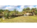 Spacious backyard overlooking a tranquil canal, abundant with palm trees at 328 Baytree Dr, Rotonda West, FL 33947