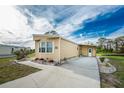 Tan mobile home with paved driveway and landscaping at 3302 Bluejay Ln, Englewood, FL 34224