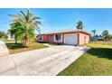 Front view of a pink house with attached garage and driveway at 3460 Lullaby Rd, North Port, FL 34287