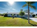 Single-story home with light gray exterior, palm tree, and driveway at 7379 Rosemont Dr, Englewood, FL 34224