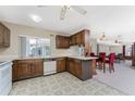 Kitchen with wood cabinets, white appliances, and adjacent dining area at 7379 Rosemont Dr, Englewood, FL 34224