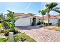 House exterior featuring a brick driveway and palm trees at 11479 Blackfin St, Venice, FL 34292