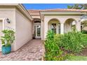 Front entrance with arched entryway, lush landscaping, and brick walkway at 13376 Creekside Ln, Port Charlotte, FL 33953