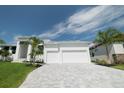 White two-story house with a three-car garage and palm trees at 159 Colony Point Dr, Punta Gorda, FL 33950