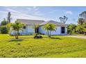 One-story home with attached garage and lush landscaping at 185 Cougar Way, Rotonda West, FL 33947