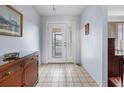 Bright entryway with tiled floor, wooden console table, and access to other rooms at 1954 Arkansas Ave, Englewood, FL 34224