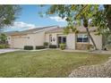 Tan house with stone accents, mature trees, and a well-manicured lawn at 2365 Malaya Ct, Punta Gorda, FL 33983