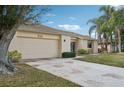 Tan house with a large garage door and a stone-accented front at 2365 Malaya Ct, Punta Gorda, FL 33983