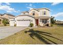 Two-story house with a three-car garage, and a well-manicured lawn at 25676 Prada Dr, Punta Gorda, FL 33955