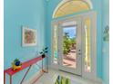 Light and airy entryway with a red console table and view to the backyard at 2864 Mill Creek Rd, Port Charlotte, FL 33953