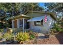 Updated mid-century home with a nicely landscaped yard and American flag at 421 Riviera St, Venice, FL 34285