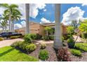 Tan house with palm trees and landscaping; a car is parked in the driveway at 4370 Turnberry Cir, North Port, FL 34288