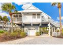 Bright white beach house with a detached garage and gray metal roof at 5000 Gasparilla Rd # 48, Boca Grande, FL 33921