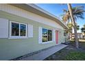 Close-up of house exterior, showcasing light green walls and pink door at 701 W Perry St, Englewood, FL 34223