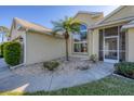 House entrance with a screened door and landscaped walkway at 80 Long Meadow Ln, Rotonda West, FL 33947