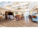 Spacious living room with hardwood floors, coffered ceiling, and leather couches at 9240 Pine Cove Dr, Englewood, FL 34224