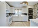 Well-equipped kitchen with white cabinets, modern appliances, and vinyl flooring at 93 Boundary Blvd # 301, Rotonda West, FL 33947